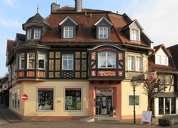 Fotografie eines historischen Fachwerkhauses mit rotem Ziegeldach und mehreren Gauben, das eine Apotheke beherbergt. 