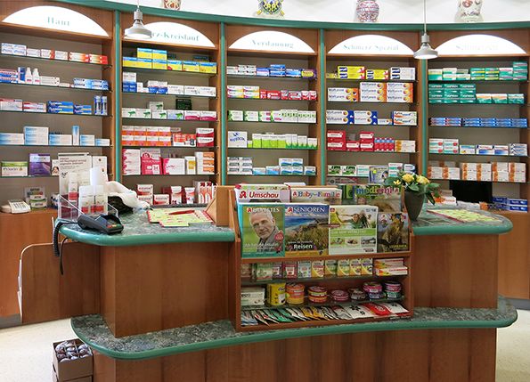 Fotografie des HV-Tisches der Park-Apotheke. Im Hintergrund Regale mit Produkten.
